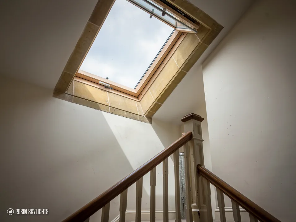 Roof window above a staircase with a timber banister