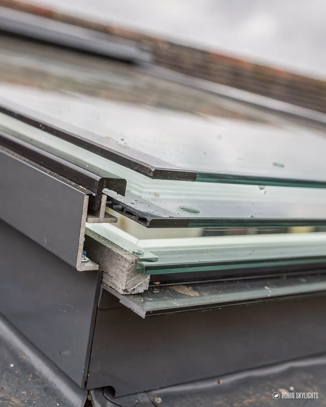 Close-up of the layered glass edge of a rooflight on its upstand