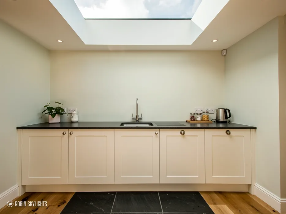 Cream kitchen units beneath a flat rooflight set into the ceiling
