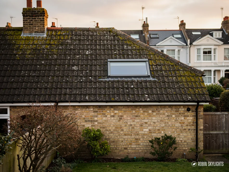 Single roof window in the tiled roof of a brick bungalow