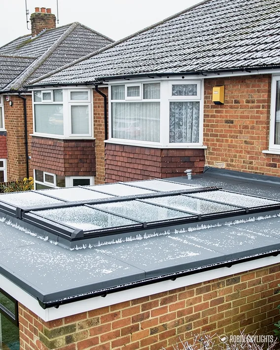 Brick extension with a roof lantern behind a semi-detached house