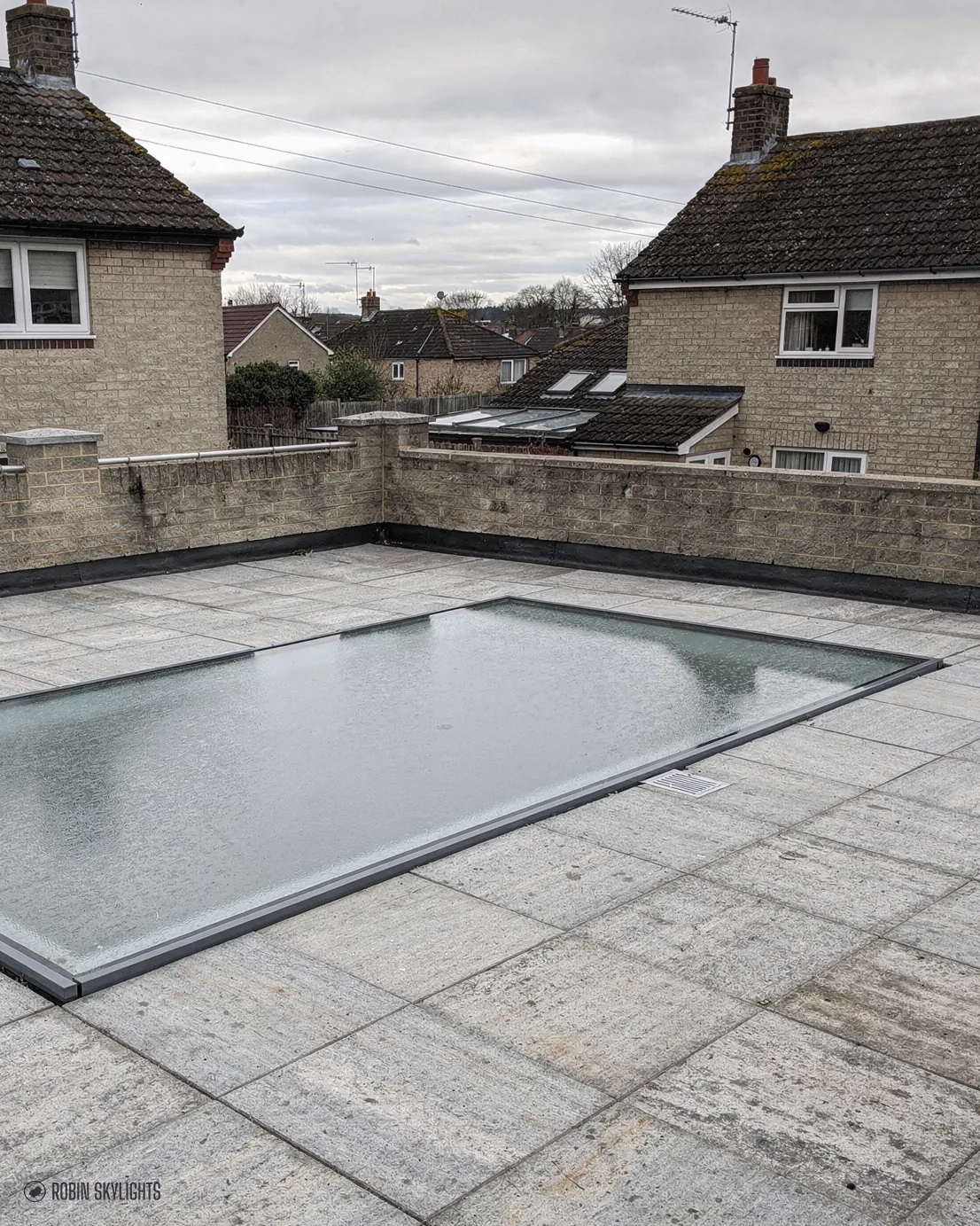 Walk-on rooflight in a stone terrace by houses