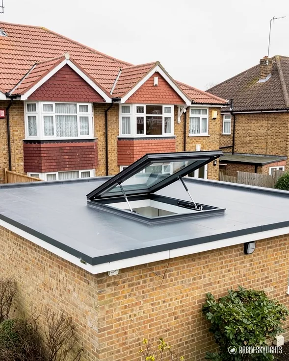 Opening rooflight raised on the flat roof of a brick extension