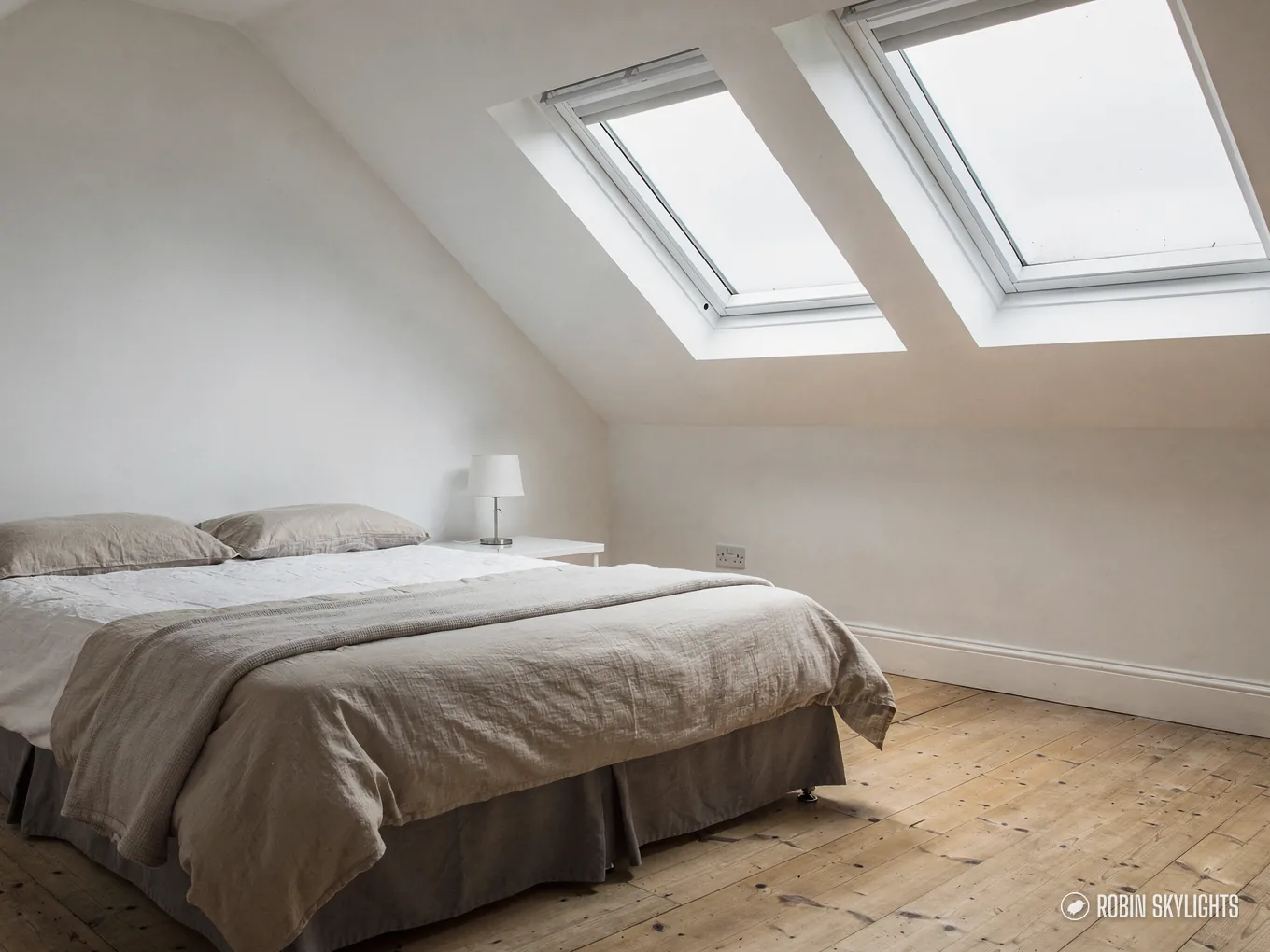 Bright loft bedroom lit by two roof windows in the slope