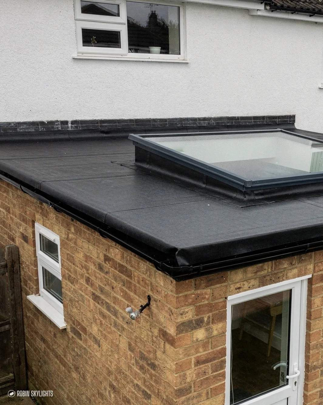 Flat rooflight on a brick extension with a white door below