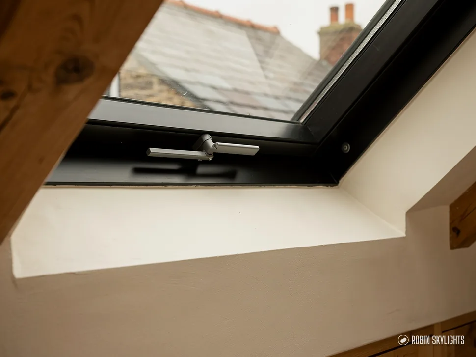 Close view of a dark roof window frame from inside a loft