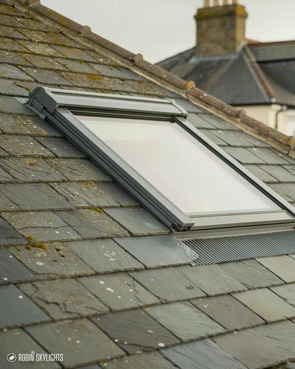 Close view of a roof window set into a grey slate roof