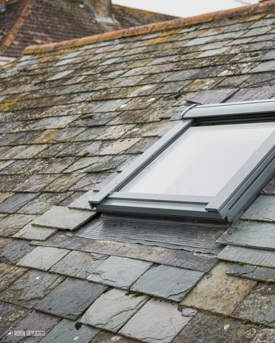 Roof window in an old grey slate roof
