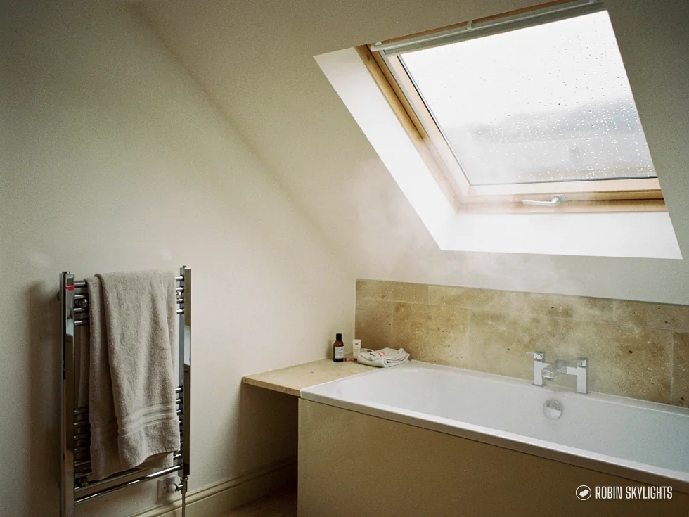 Bathroom with a towel rail and bath under a roof window