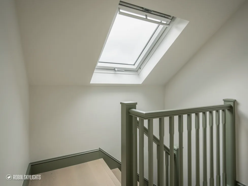 Landing with a white staircase under a roof window