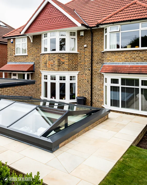 Brick house with a roof lantern on its extension over a stone patio