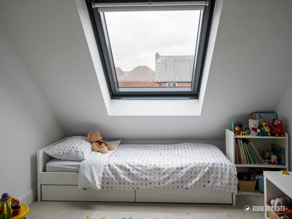 Child's bedroom with a single bed beneath a roof window
