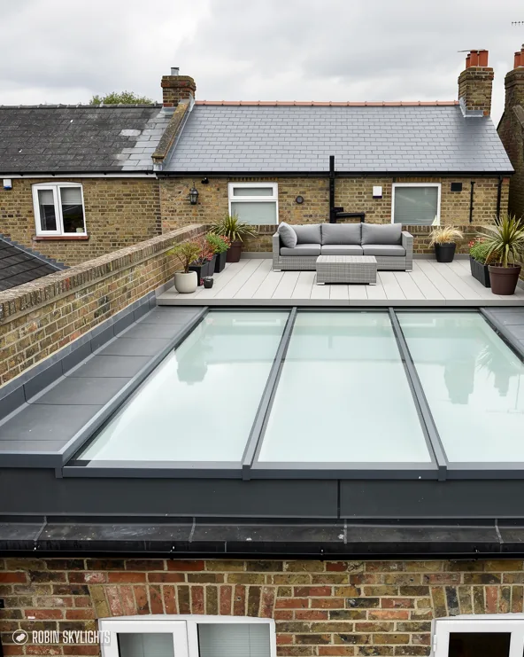 Long flat rooflight on a rear extension below brick terraced houses