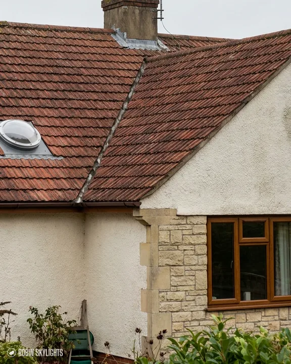 Sun tunnel dome in a red tiled roof above a rendered cottage
