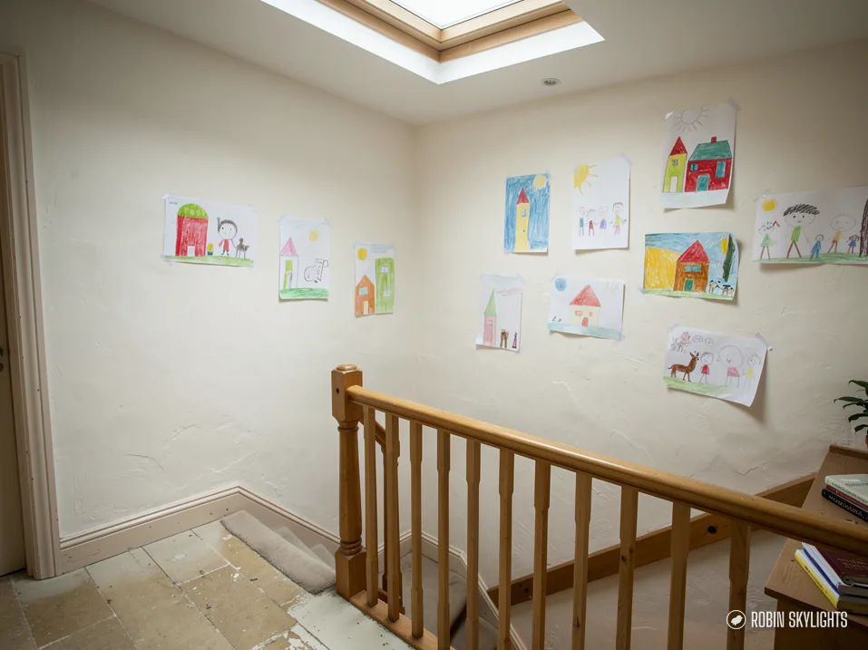 Landing with children's drawings on the wall and a rooflight above