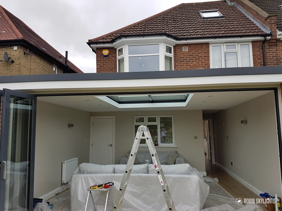 Room with a flat rooflight in the ceiling and folding doors