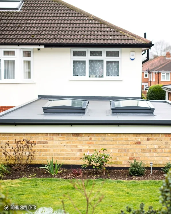 White bungalow with two flat rooflights on its single-storey extension
