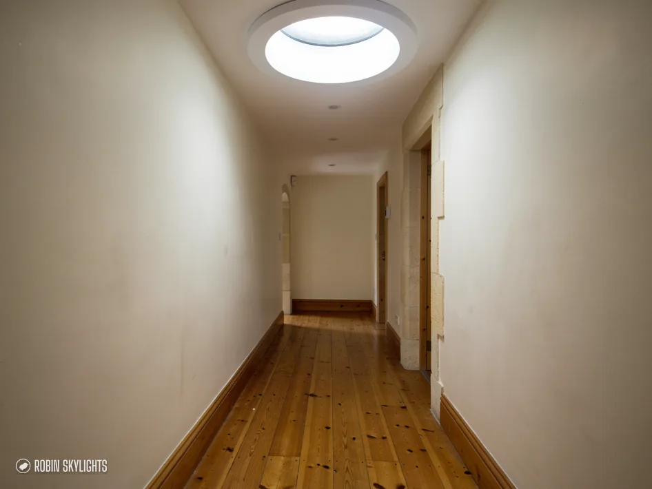 Corridor lit by a round sun tunnel diffuser in the ceiling