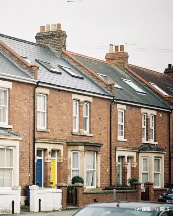 Row of Victorian brick terraced houses with coloured front doors