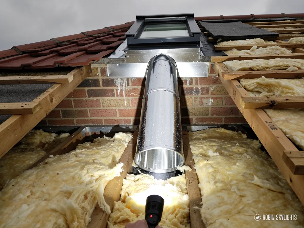 Sun tunnel tube passing through loft insulation between joists