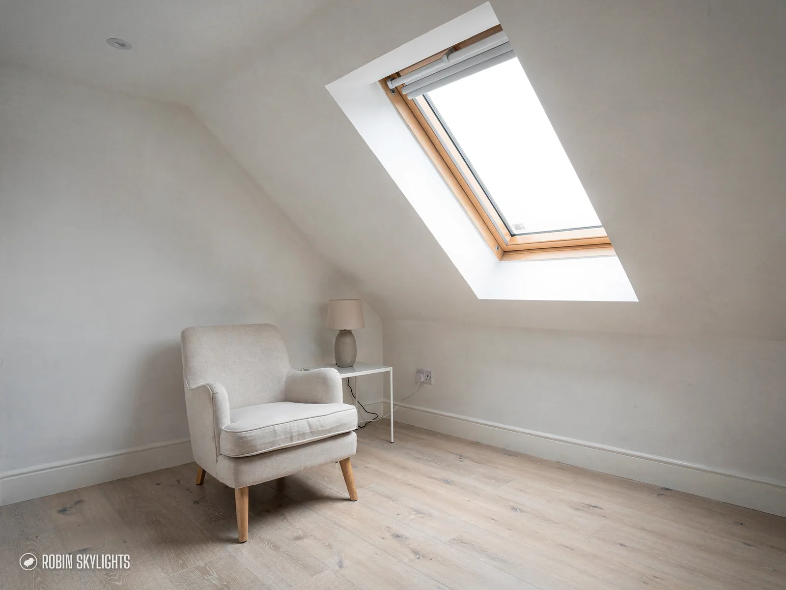 White armchair in a loft room beneath a roof window