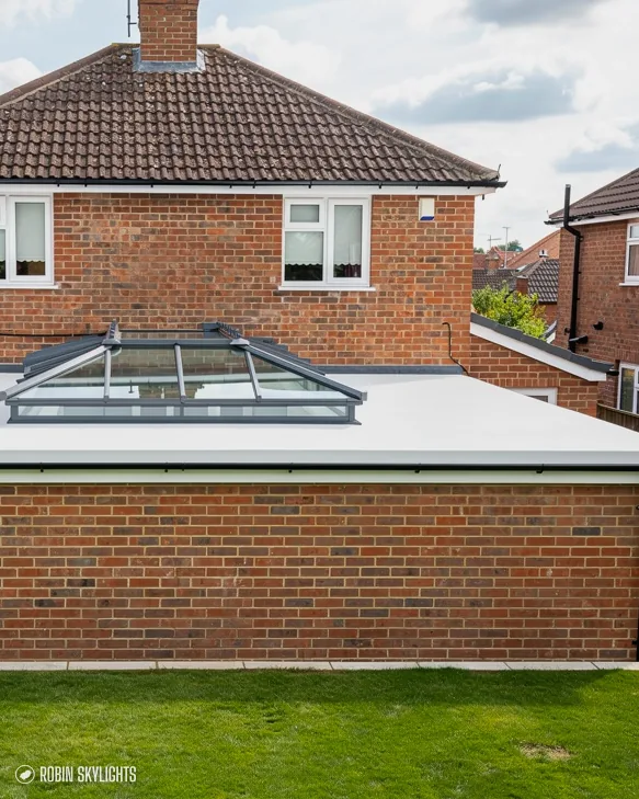 Brick house with a roof lantern on its rear extension and lawn