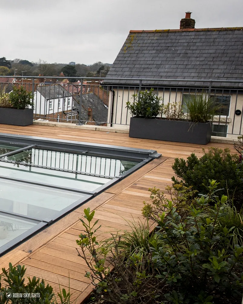 Flat rooflight on a roof terrace with timber decking and planters