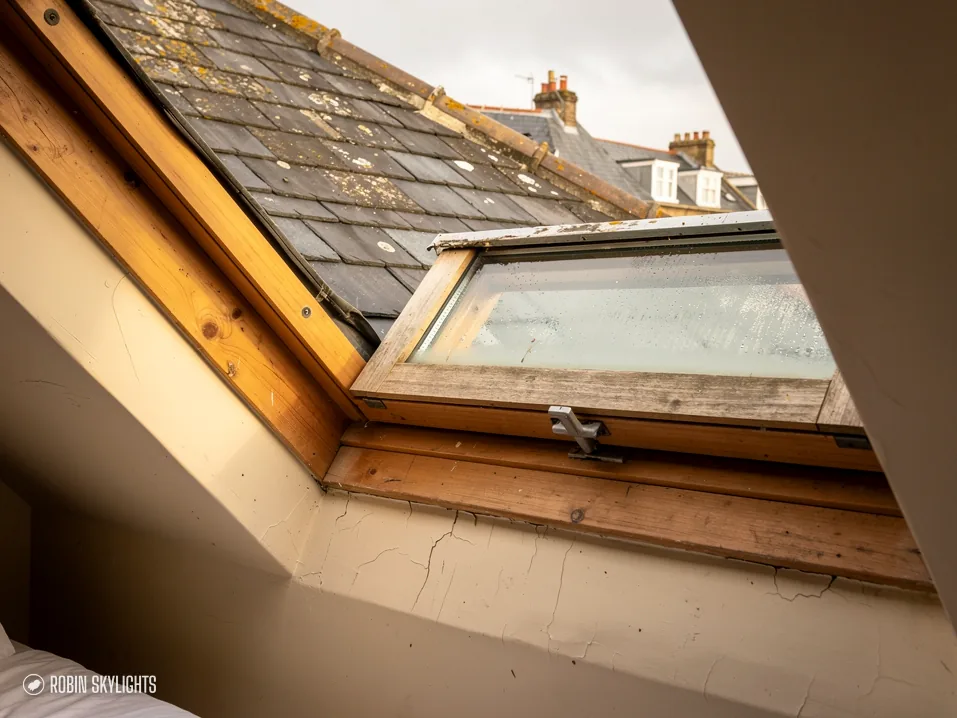 Open pine roof window seen from inside a slate roof