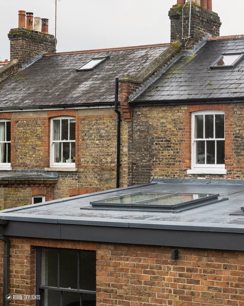 Flat rooflight on a rear extension below a row of brick terraced houses