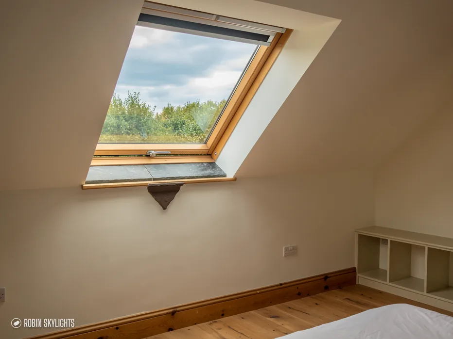 Empty room with wooden floor under a pine roof window