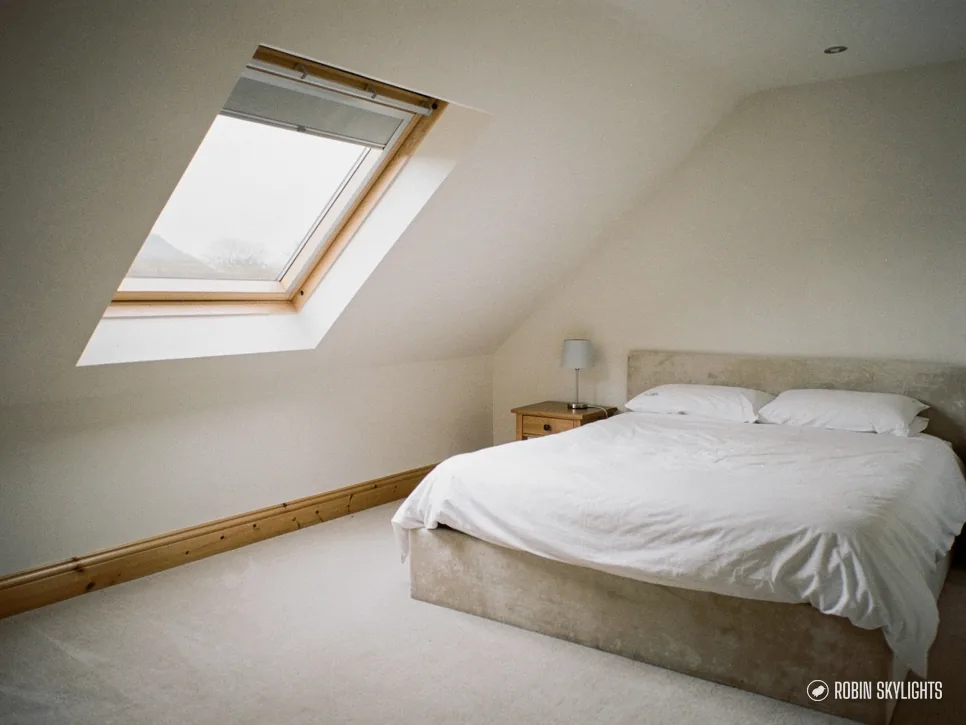 Bedroom with a double bed under a white roof window